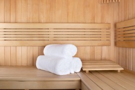 Traditional wooden sauna for relaxation with set of clean towels